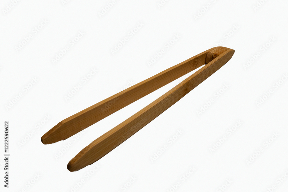 New bamboo kitchen tongs designed for grilling and serving, isolated on white. The clean, detailed shot emphasizes the natural material and functional design of this essential cooking utensil. New bamboo kitchen tongs designed for grilling and serving, isolated on white. The clean, detailed shot emphasizes the natural material and functional design of this essential cooking utensil.