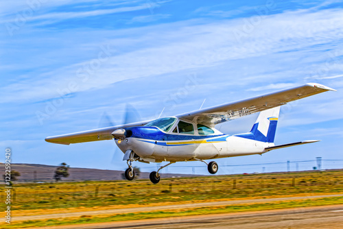 Sleek single engine, high wing, blue and white aircraft taking off from an airstrip in the Western Cape, South Africa