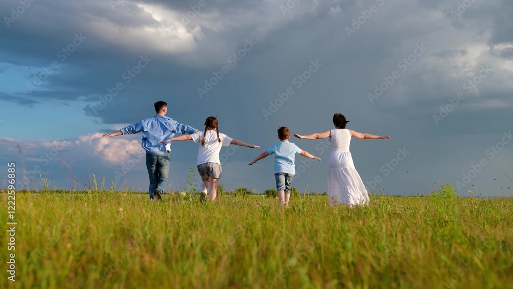 Mom dad kids play superheroes with hands up in park. Happy family playing in nature park. Mother daughter father son run on meadow dreaming about flying to sky slow motion. Happy family play in nature Mom dad kids play superheroes with hands up in park. Happy family playing in nature park. Mother daughter father son run on meadow dreaming about flying to sky slow motion. Happy family play in nature