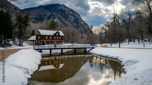 Red House Reflects in the Canal with Snowy Banks on a Cloudy Day in Winter with Mountains
