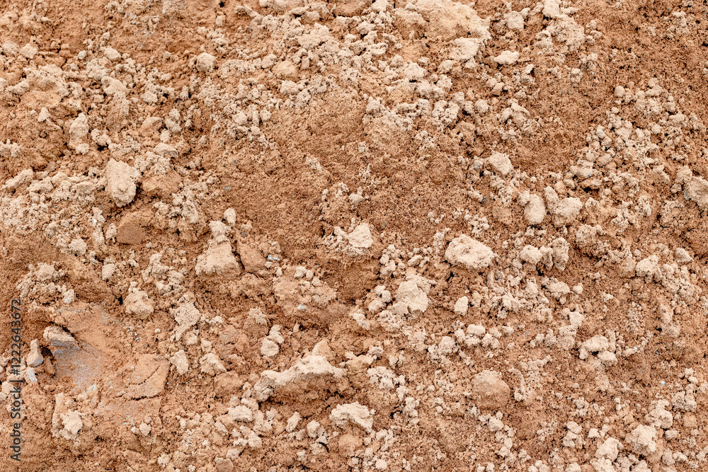 Textured brown soil surface with small rocks and uneven terrain Textured brown soil surface with small rocks and uneven terrain