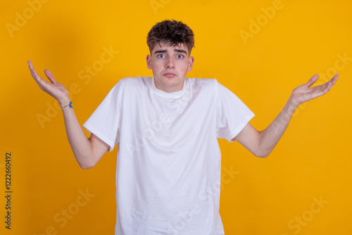 young man isolated on color background with expression of incomprehension photo