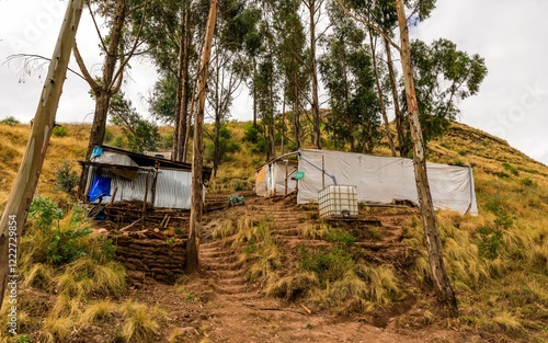 Makeshift hillside shelters with water tank photo