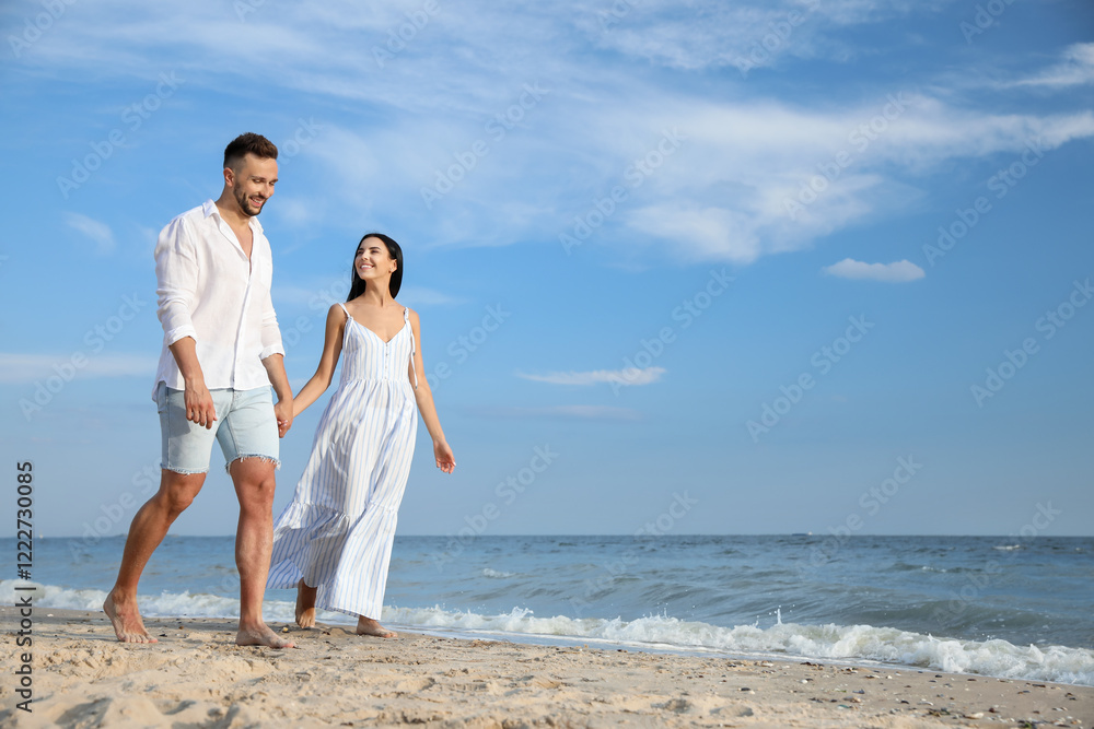 Happy young couple walking together on beach Happy young couple walking together on beach