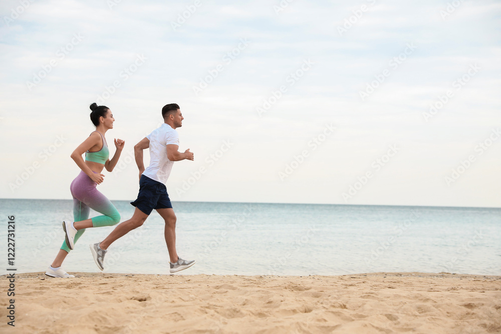 Couple running together on beach, space for text. Body training Couple running together on beach, space for text. Body training