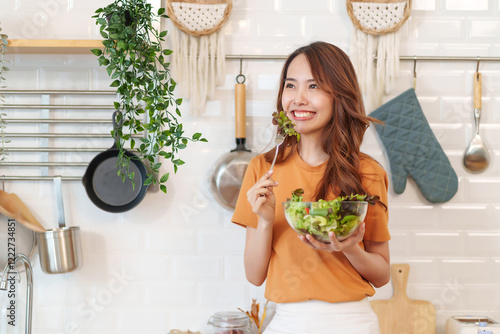 portrait slim asian woman eating vegetables salad,healthy food,vegan,vegetables salad,cooking in the kitchen