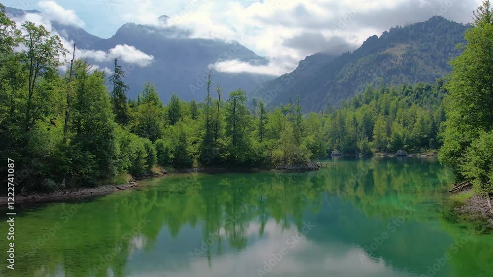 Aerial of alpine paradise emerald lake Odsee with crystalline waters and pine forest. Summertime in Austria. Aerial of alpine paradise emerald lake Odsee with crystalline waters and pine forest. Summertime in Austria.