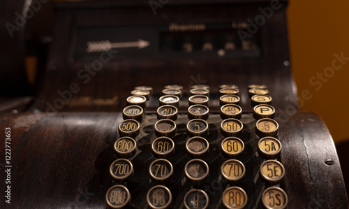 Closeup of an antique wooden cash register with rounded keys photo