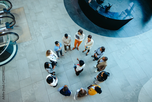 Fotografie Team gathering in a circular formation within a modern office lobby