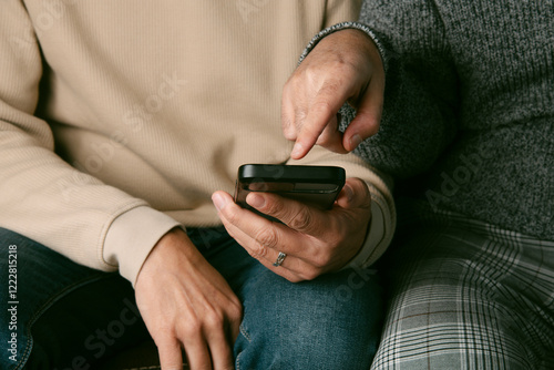 man shows something in his smartphone to his partner photo