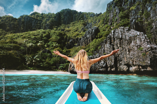 Fotografie Woman tourist traveling in Philippines, girl happy raised hands on the boat isla