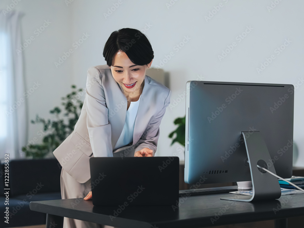 女性、オフィス、キャリアウーマン、ビジネスウーマン、笑顔、ノートパソコン、PC、デスクトップ、デスクワーク、ミドルエイジ、キャリア、夜、暗い、DX、デジタルトランスフォーメーション、仕事、職場、チェック、元気、忙しい、データ、働く、作業、営業、スーツ、ビジネス、オフィスシーン、ビジネスシーン、室内、インテリア、デスク、編集者、出版、校正、ジャーナリスト、記者、ライター、記事、ニュース、嬉しい、喜ぶ