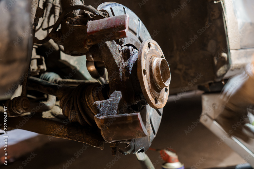 Fototapeta premium Detailed Close-Up of an Automotive Brake Assembly in a Garage Setting