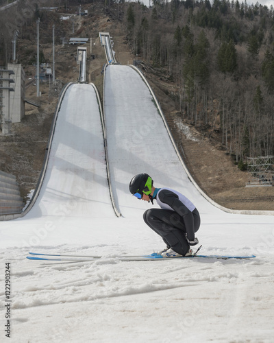 Young male ski jumper in the outrun at a training on snow. photo