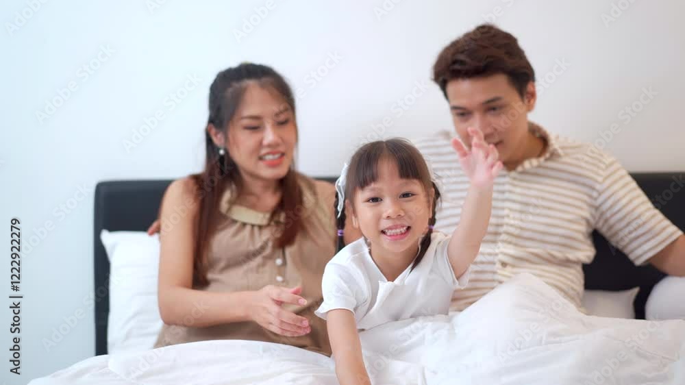 Asian family with father, pregnant mother, and daughter are relaxing and talking together. Asian family with father, pregnant mother, and daughter are relaxing and talking together.