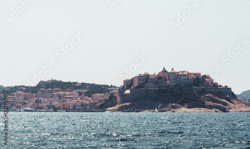 Ville de Calvi en Haute Corse, vue depuis le large dans la baie, sur un bateau, en plein été.