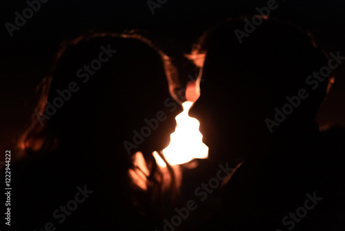 A couple in love, a guy and a girl are sitting on the seashore in an embrace face to face, at night near a burning fire, moonlit night, fire, silhouettes, nature, love story, holiday, love, Valentine'