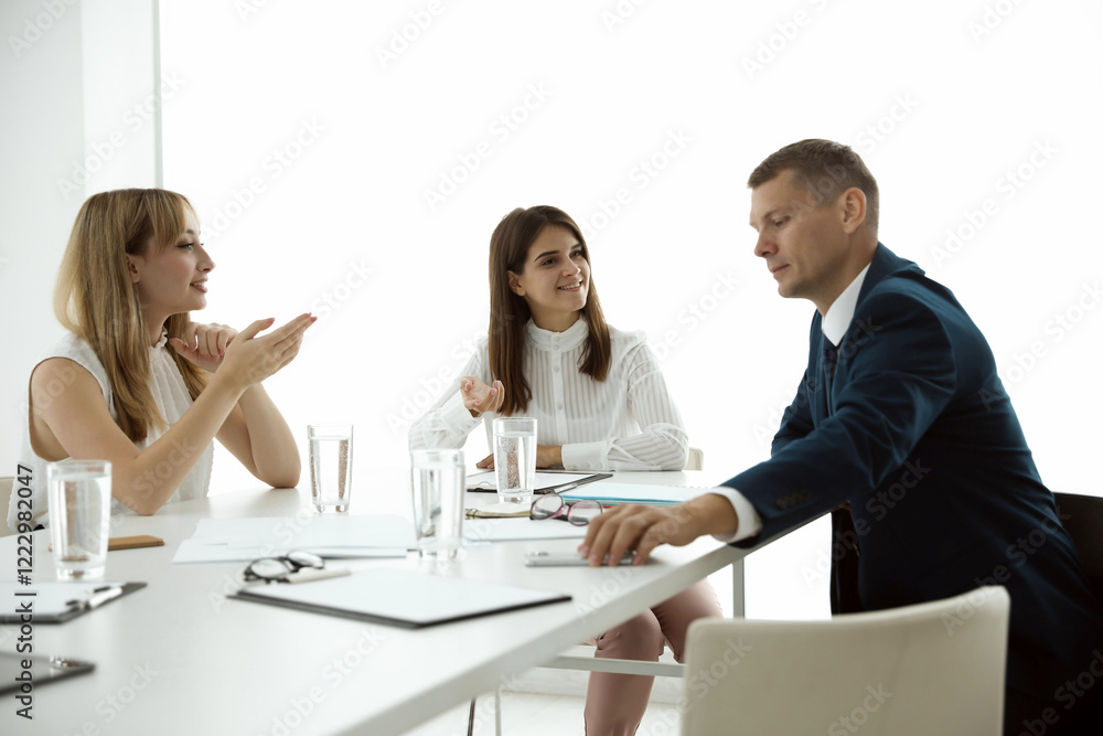 Office employees talking at table during meeting Office employees talking at table during meeting