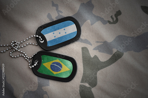 vintage army blank, dog tag with flag of honduras and brazil on the khaki texture background. military concept. photo