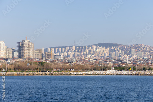 A stunning panoramic view of Istanbul’s Asian coastline captured from a ferry cruising on the Marmara Sea during a serene evening. A cinematic and vibrant maritime scene.