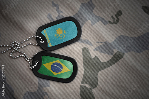 vintage army blank, dog tag with flag of kazakhstan and brazil on the khaki texture background. military concept. photo