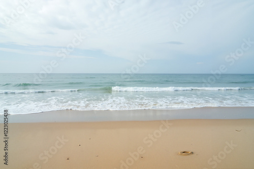 Sandy beach with gentle waves at sunset