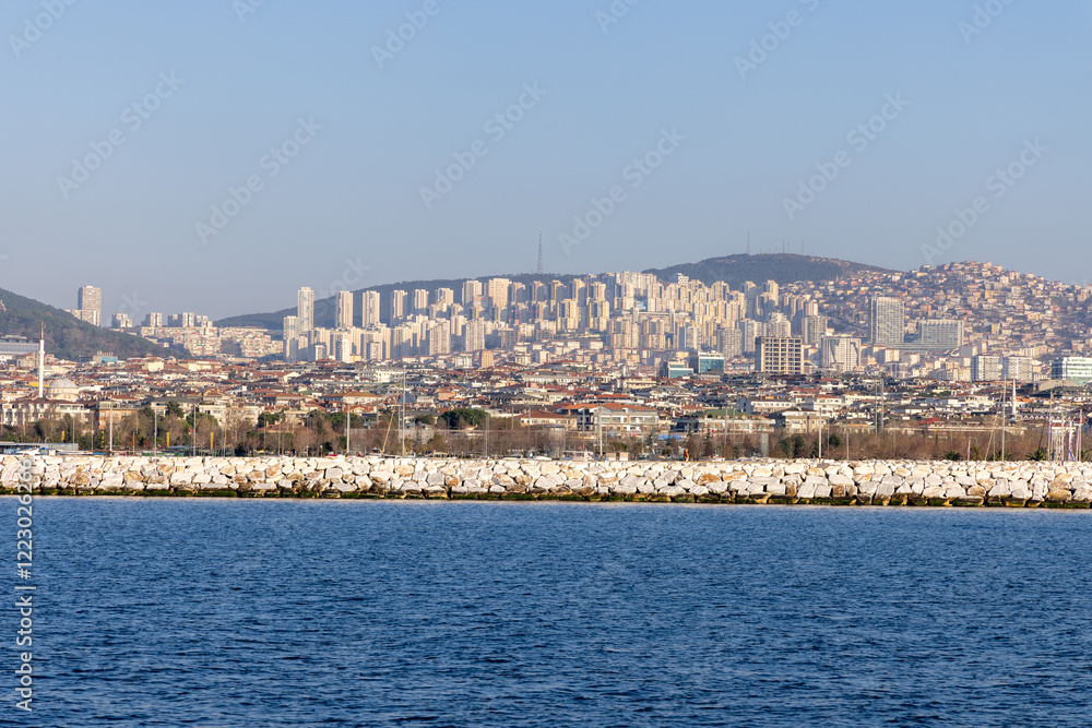 Fototapeta premium Skyline of Istanbul’s Asian side with modern residential buildings and a rocky shoreline. A vibrant view of the Anatolian side blending urban development and coastal beauty. Panaromic Istanbul 2025
