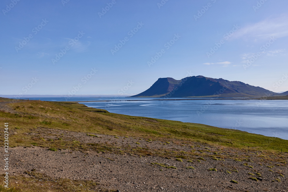 Dramatic coastal landscape with mountain and fjord in Iceland. Pristine blue water meets rugged terrain. Travel destination, Nordic nature, and wilderness scenery background. Dramatic coastal landscape with mountain and fjord in Iceland. Pristine blue water meets rugged terrain. Travel destination, Nordic nature, and wilderness scenery background.
