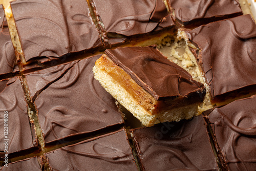 Caramel shortbread, also known as caramel squares, slice, or millionaire's shortbread. Dessert, cake made with  shortbread biscuit base topped with caramel and chocolate. Food background. photo