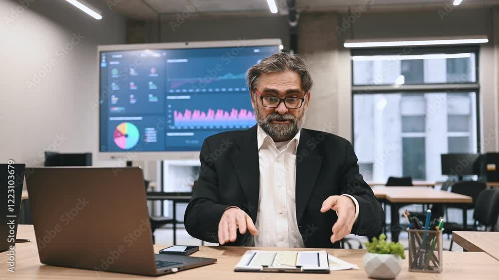 Angry dissatisfied businessman in a formal suit arguing sitting at workplace in business office. Excited man boss talks with subordinate about problems Angry dissatisfied businessman in a formal suit arguing sitting at workplace in business office. Excited man boss talks with subordinate about problems