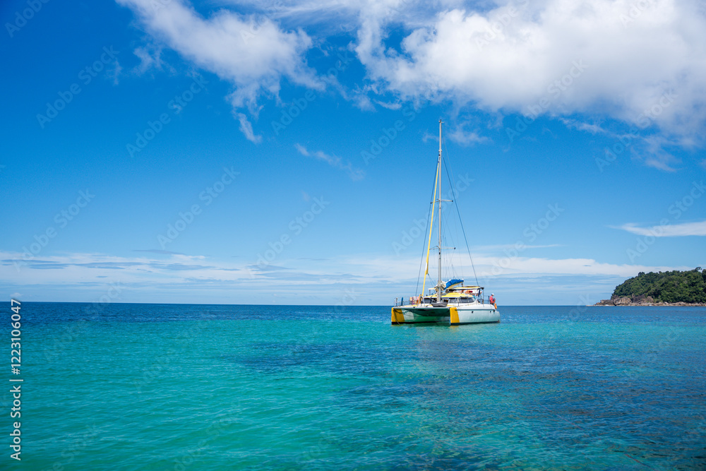 turquoise ocean water against blue sky with white clouds and tropical island. Summer vacation, tropical beach with turquoise water, summer holidays vacation turquoise ocean water against blue sky with white clouds and tropical island. Summer vacation, tropical beach with turquoise water, summer holidays vacation