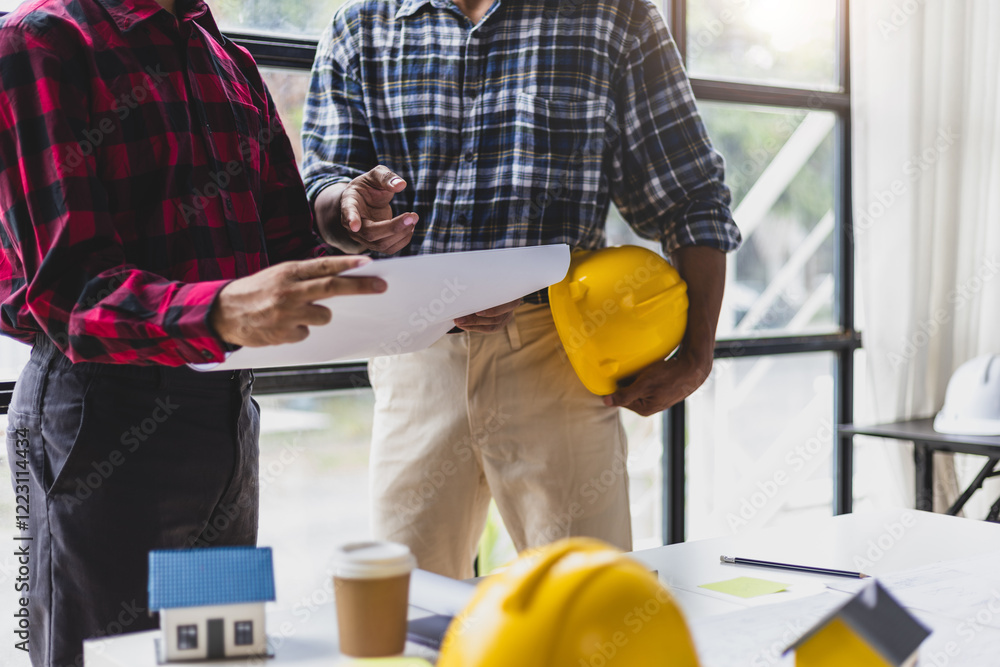 Architect colleague in the office is talking with a contractor and discussing the correct planning of a construction project according to the design. Architect colleague in the office is talking with a contractor and discussing the correct planning of a construction project according to the design.