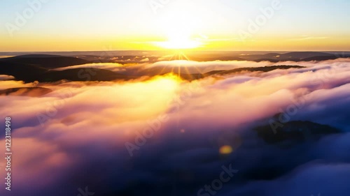 Wallpaper Mural A breathtaking sunrise casting golden light over a sea of clouds, creating a peaceful and dreamy atmosphere with warm and soft hues.  FPV of flying through clouds toward the sun, 4k video footage.
 Torontodigital.ca