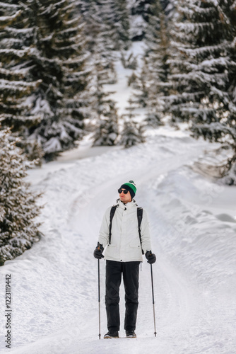 Obraz na płótnie Man Hiking with Trekking Poles in Snow Forest w salonie