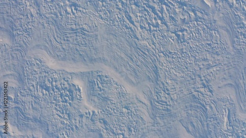 Aerial view of a snowy field with a strong wind