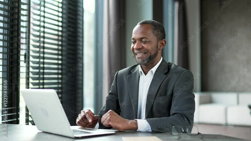Happy african american businessman finished work on laptop while sitting at workplace in business office. Smiling satisfied black man puts his hands behind his head, leaning back in chair. Work done Happy african american businessman finished work on laptop while sitting at workplace in business office. Smiling satisfied black man puts his hands behind his head, leaning back in chair. Work done