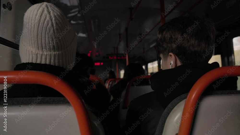 A view of passengers seated inside a tram, including a woman in a white hat and a young man in a black jacket. Perfect for urban commuting, public transport, and daily routines. A view of passengers seated inside a tram, including a woman in a white hat and a young man in a black jacket. Perfect for urban commuting, public transport, and daily routines.