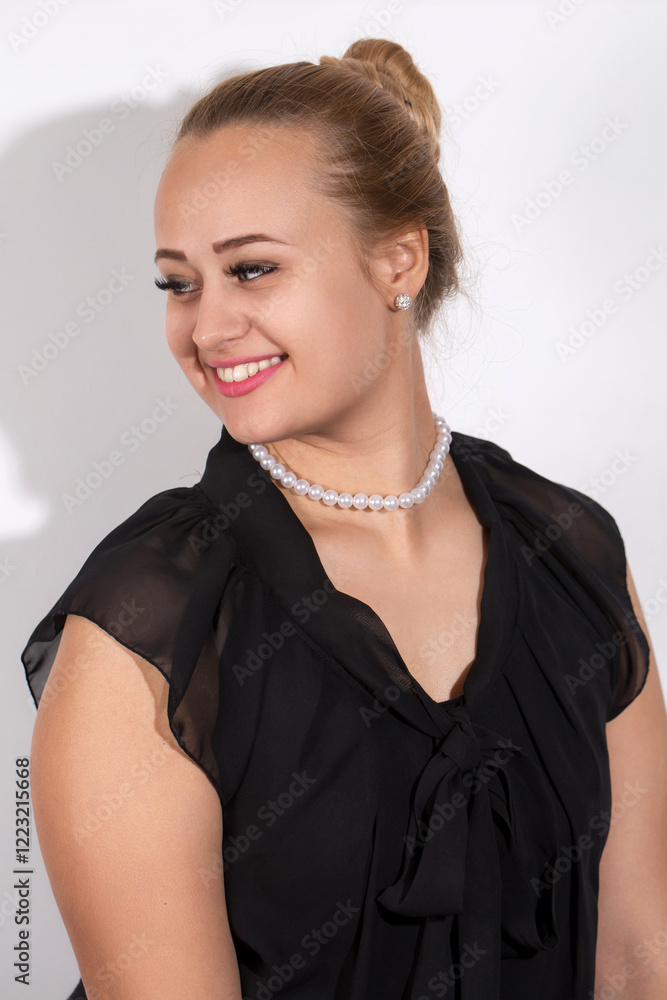 A woman wearing a black dress and a pearl necklace