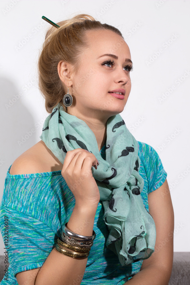 Woman in a turquoise scarf with black patterns