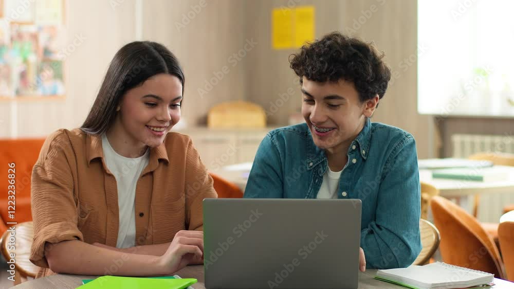 Two Caucasian students pupils school mates girl woman female guy male man studying e-learning together education laptop online prepare exams high five gesture cooperation teamwork friends agreement Two Caucasian students pupils school mates girl woman female guy male man studying e-learning together education laptop online prepare exams high five gesture cooperation teamwork friends agreement