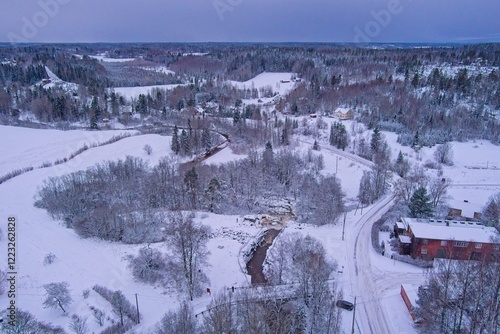 Aerial view of Kuhakoski rapids on a cold winter day with snow covered ground and tree branches, Nurmijärvi, Finland. photo