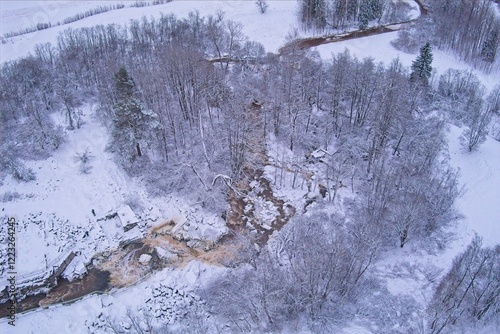 Aerial view of Kuhakoski rapids on a cold winter day with snow covered ground and tree branches, Nurmijärvi, Finland. photo