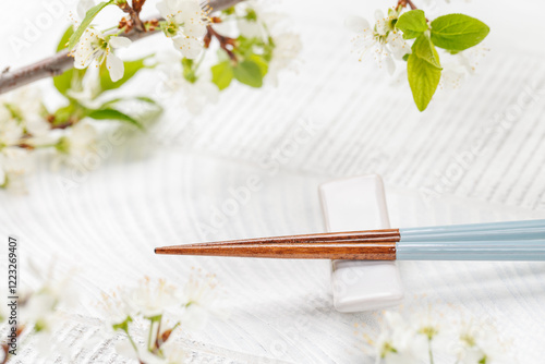 Fotografie Table adorned with cherry blossom branch and chopsticks, epitomizing Japanese fo