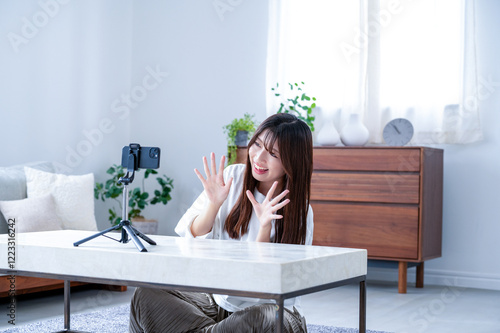 фотографія 笑顔で動画撮影をする日本人女性