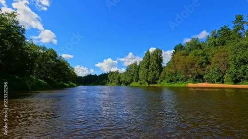 Wallpaper Mural A calm river surrounded by lush green trees under a bright blue sky, peaceful nature Torontodigital.ca