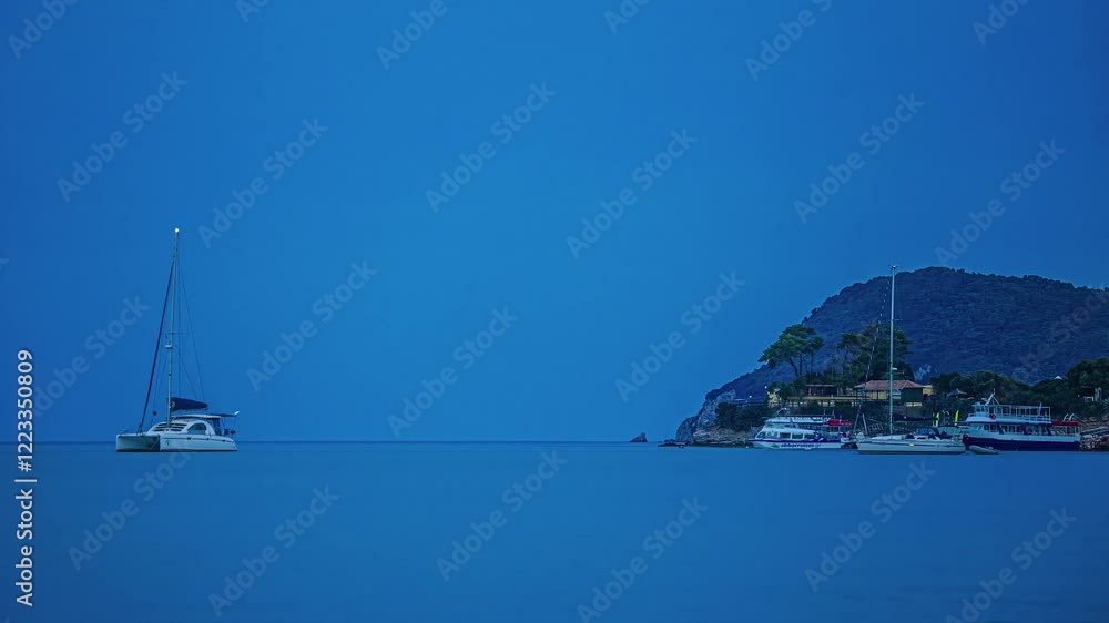 This captivating time lapse captures the serene beauty of boats gently moored in the evening light. The tranquil blue scenery highlights the peaceful ambiance of the harbor. This captivating time lapse captures the serene beauty of boats gently moored in the evening light. The tranquil blue scenery highlights the peaceful ambiance of the harbor.