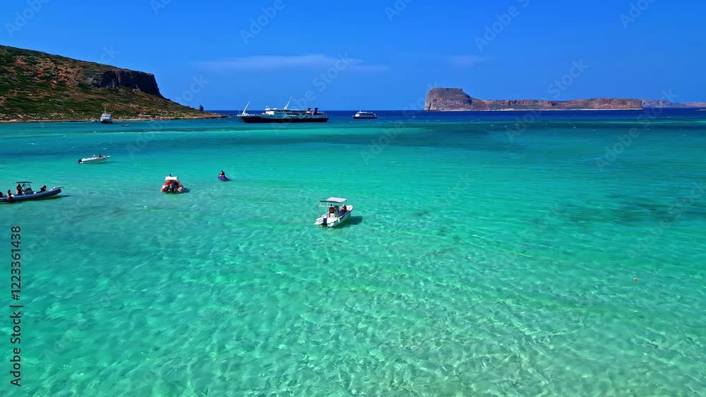 Clear waters with small boats at Afrata Beach, surrounded by coastline in Crete, Greece Clear waters with small boats at Afrata Beach, surrounded by coastline in Crete, Greece
