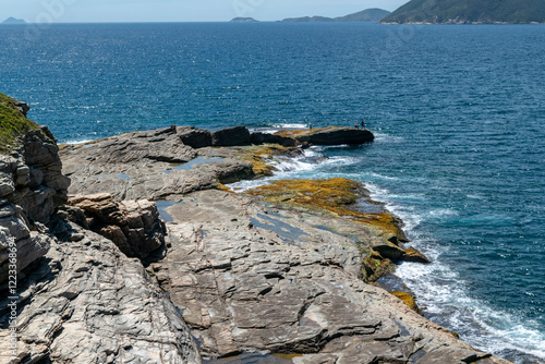 View from above of Conchas beach, Cabo Frio, Rio de Janeiro. With many rocks bathed by the sea and mountains in the background. photo