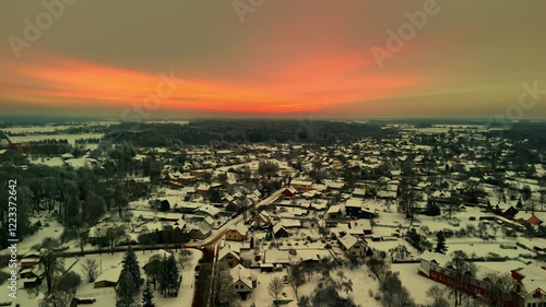 Experience the breathtaking beauty of Saldus as dawn breaks, illuminating the snow-covered town. The serene landscape glows with soft colors that enhance the winter charm. photo