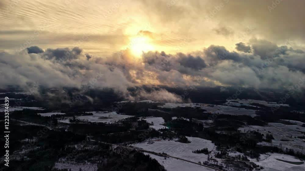 Drone view of sunrays getting blocked by thick clouds in sky after snowfall in town. Drone view of sunrays getting blocked by thick clouds in sky after snowfall in town.
